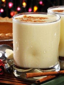 Glasses of holiday egg nog with a pumpkin pie in the background