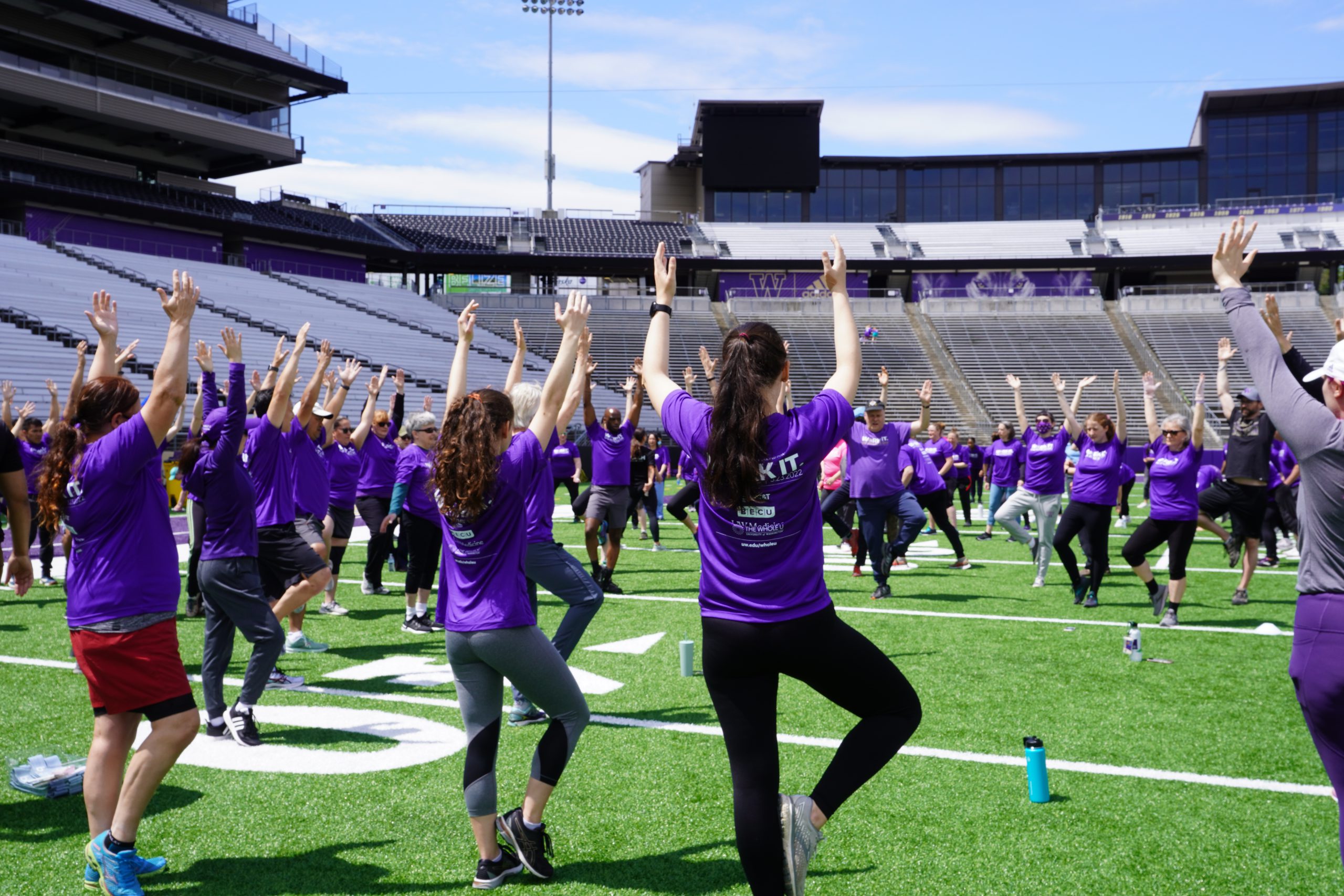 UW Fitness Day participants stand on one leg with hands in air