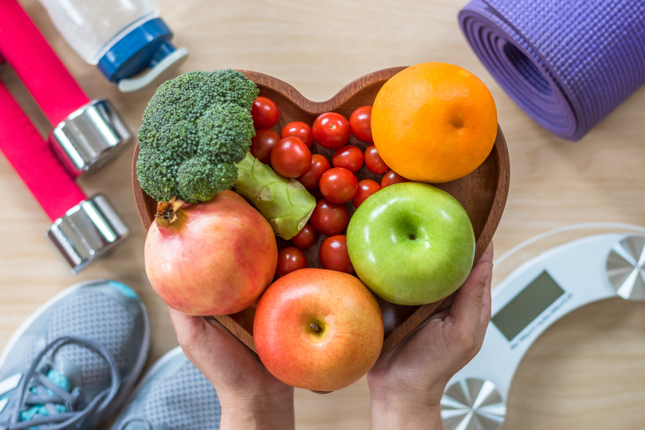 fruit and vegetables in bowl with exercise equipment in background
