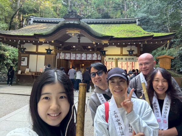 Kevin and his family in law smiling in front of a Japanese Temple.