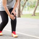 Sports injury. Woman with pain in knee while jogging