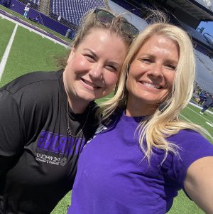 Two women take a selfie on a sports field