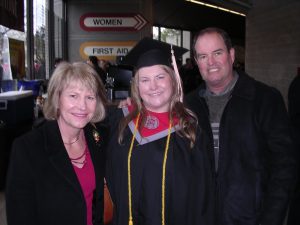 A young woman graduate with her parents
