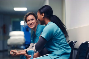 2 female healthcare professionals sit and chat