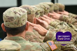 several military personnel saluting in a line facing forward.