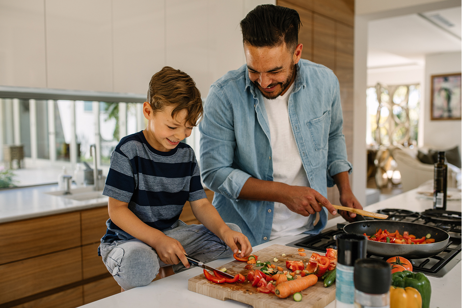 father and son chopping vegetables in kitchen