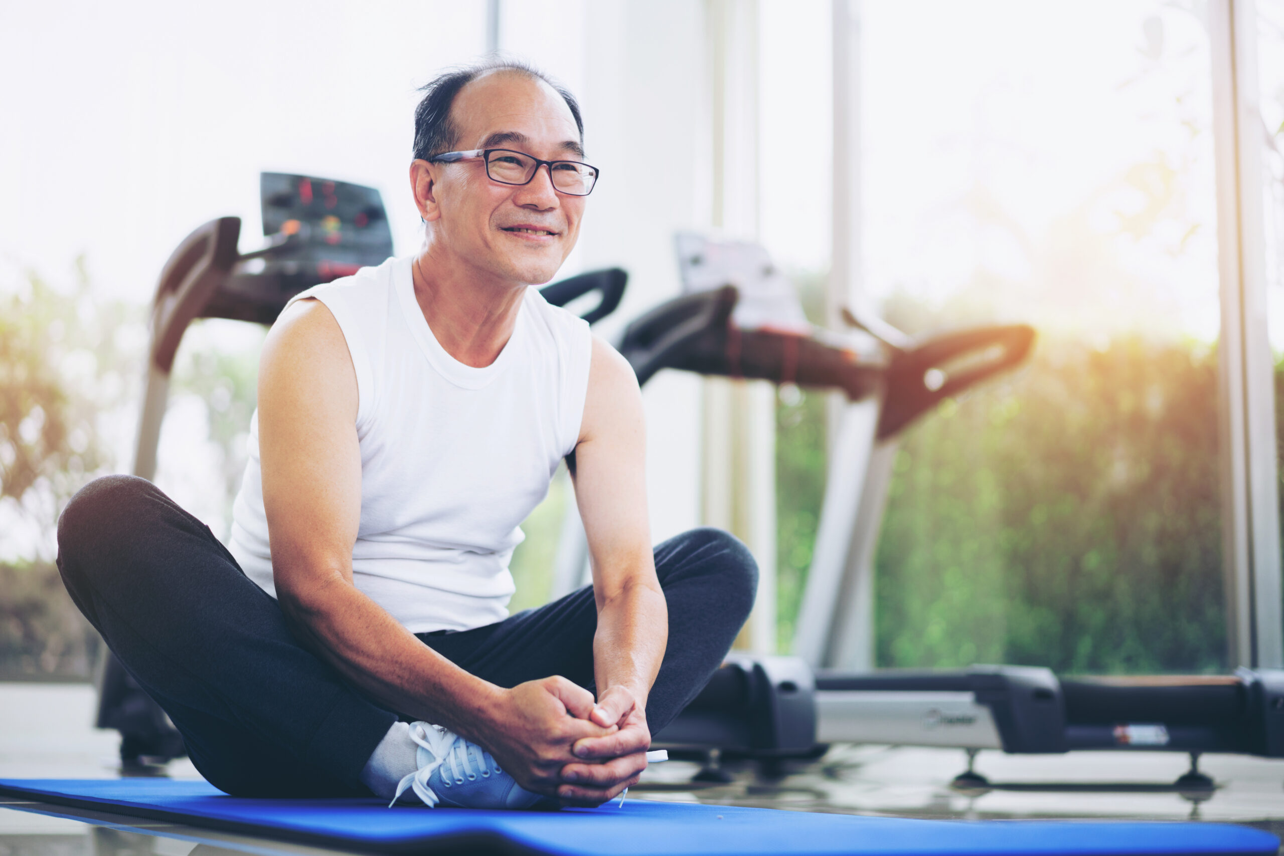 older man stretching on mat
