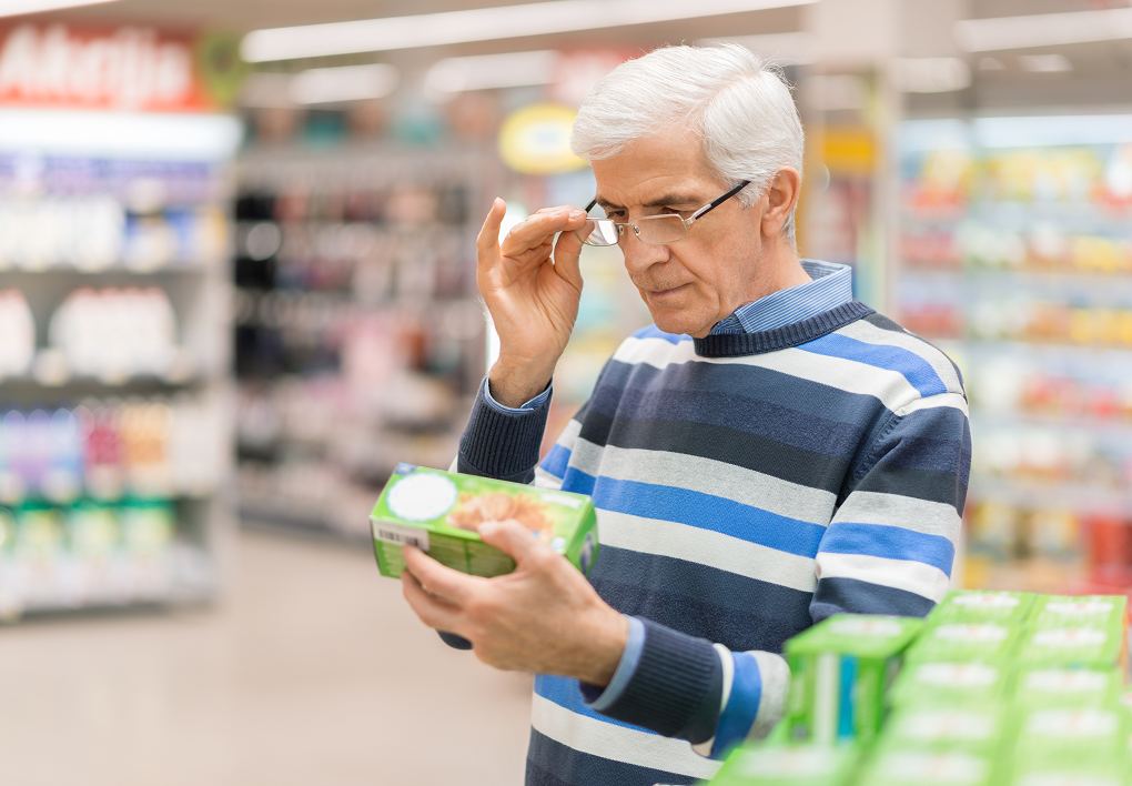 man reading food label in store