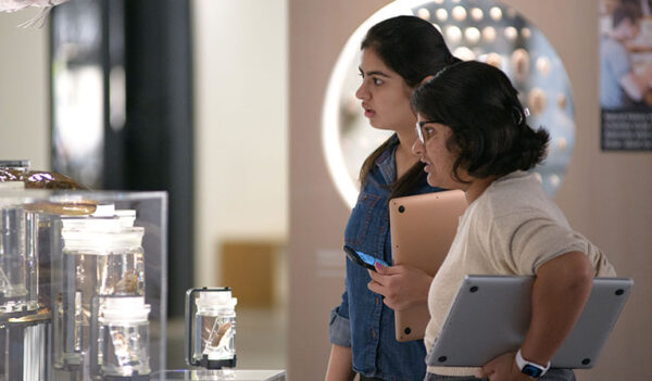 two teen girls holding laptops